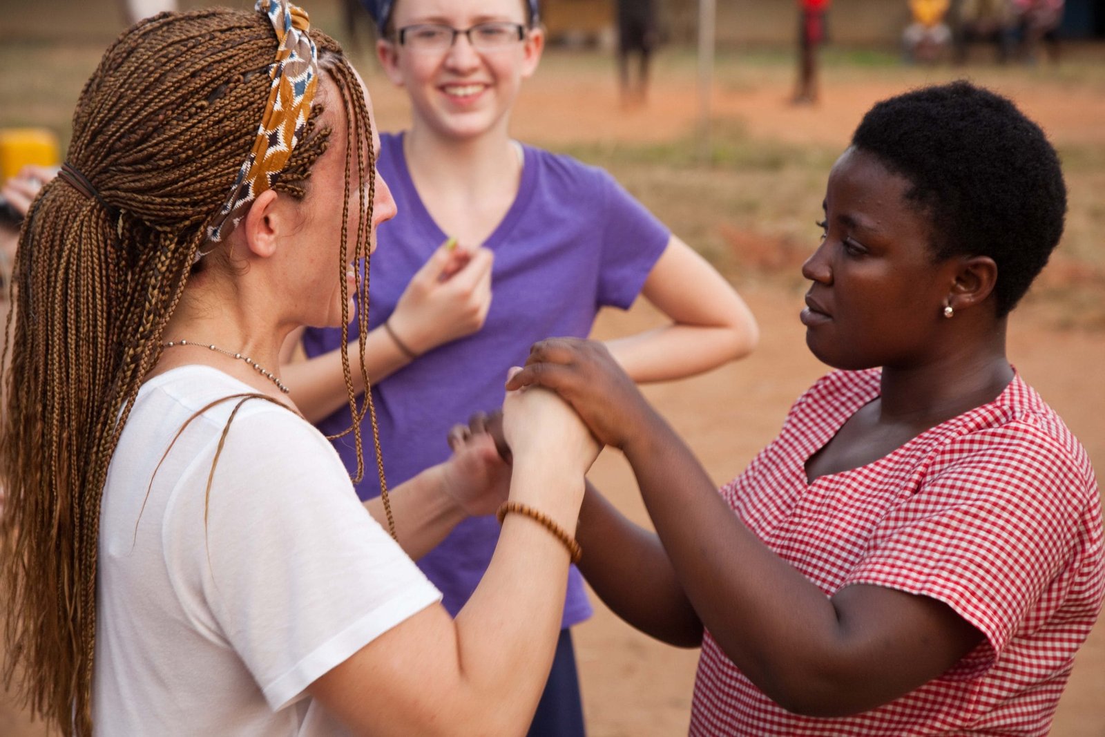 A woman is watching 2 other women holding hands